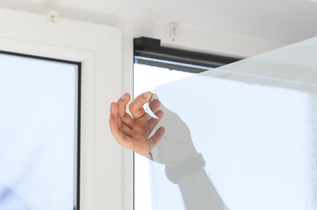 Installation von getönter Folie. Ultraviolett- und Energieeffizienzkonzept.